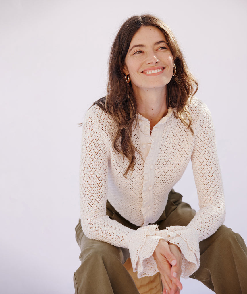 Woman in a cream knit top from Christy Lynn