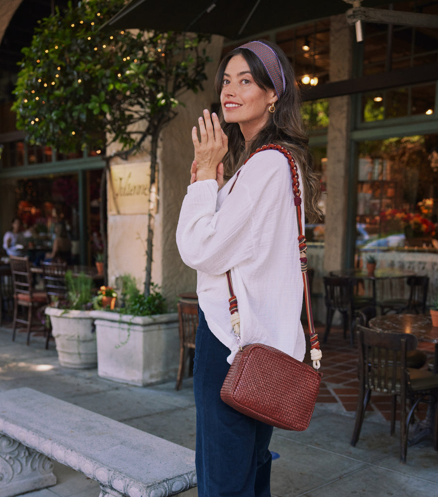woman standing in front of cafe wearing aslection of serafina accessories